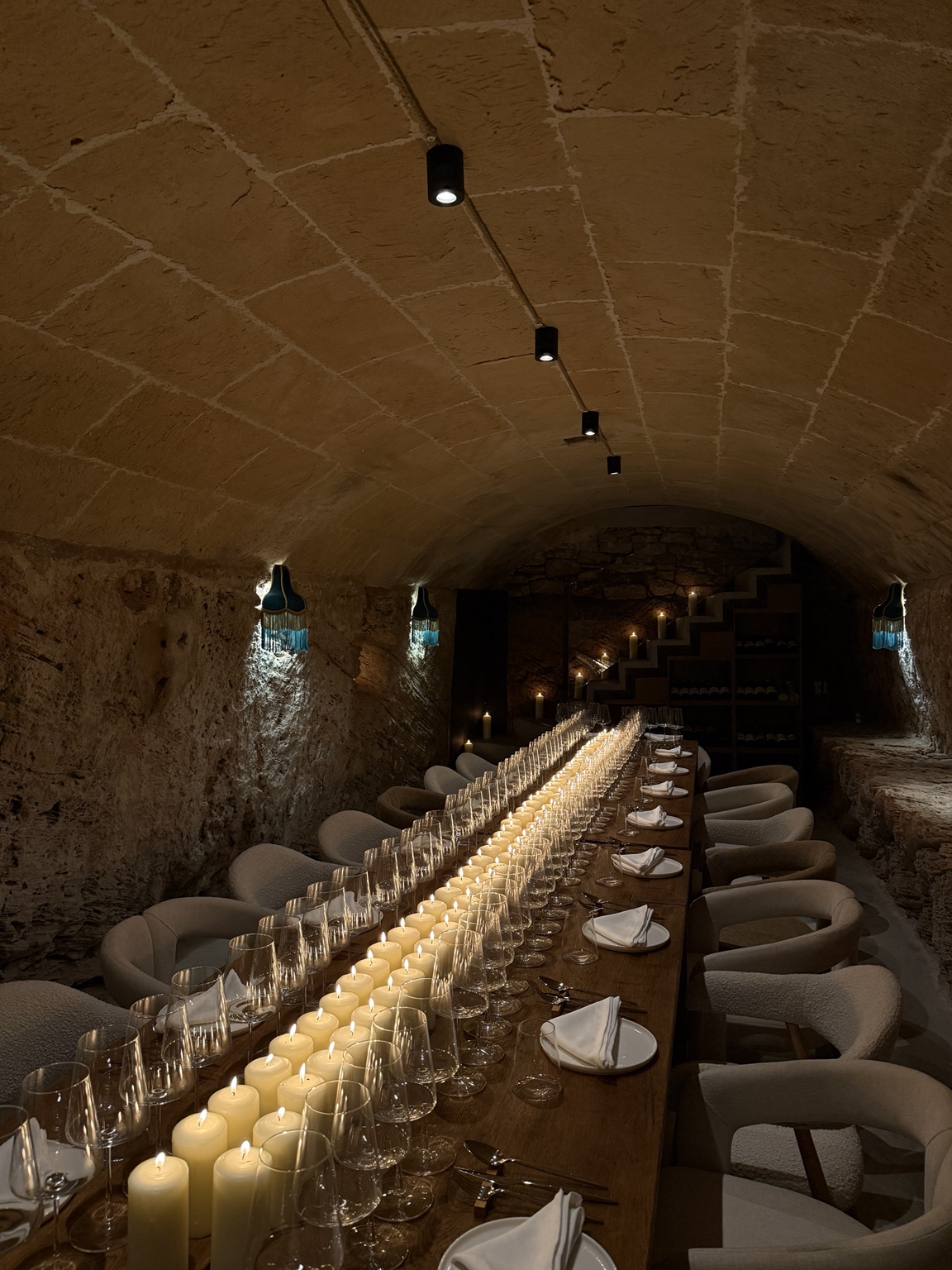 La mesa de Es Celler preparada entre velas, piedra y los antiguos pesebres