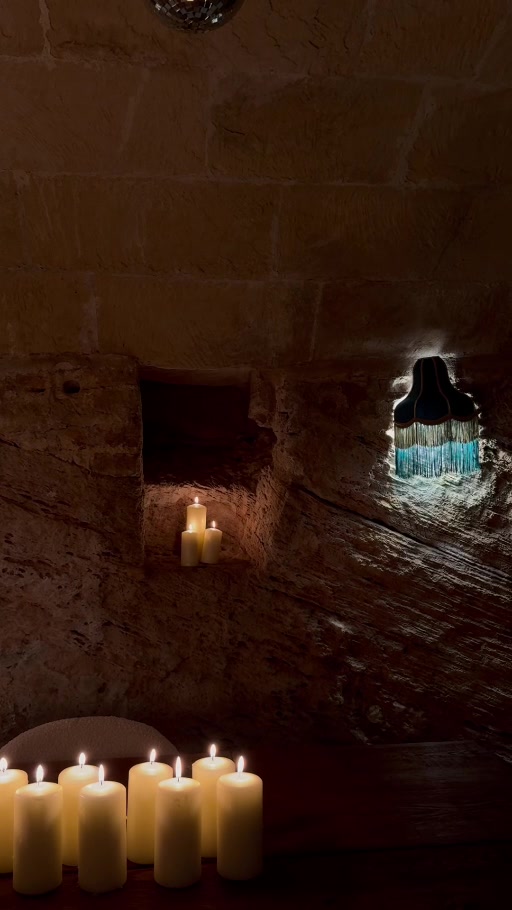 La piedra del antiguo celler, iluminada por una lámpara y velas